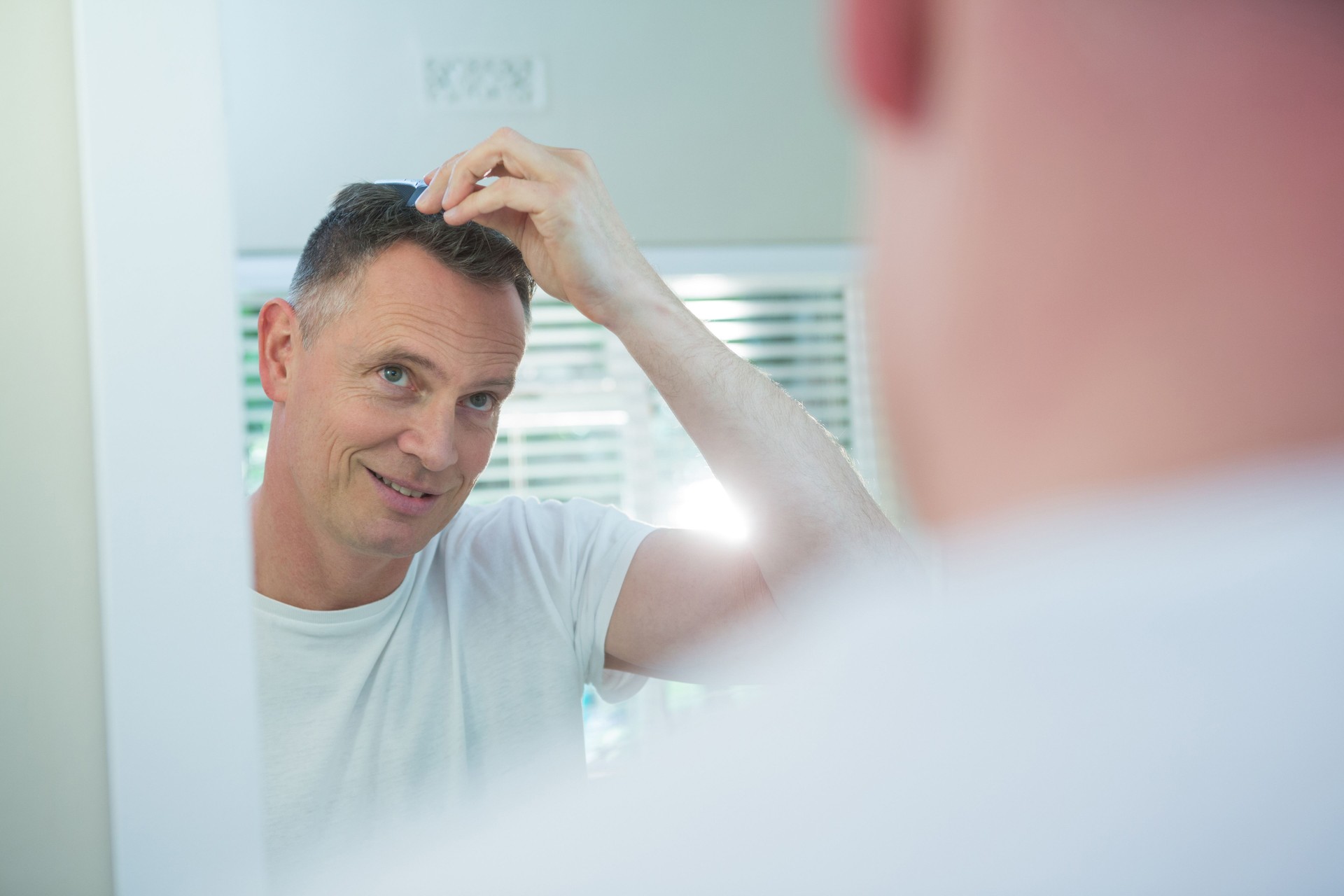 Man combing his hair in bathroom